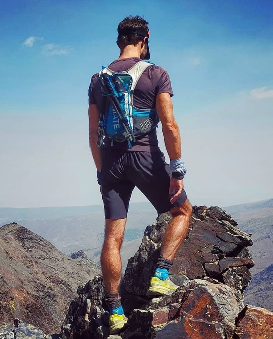 Chris Dale en una cresta de Sierra Nevada, con chaleco y bastones de trail